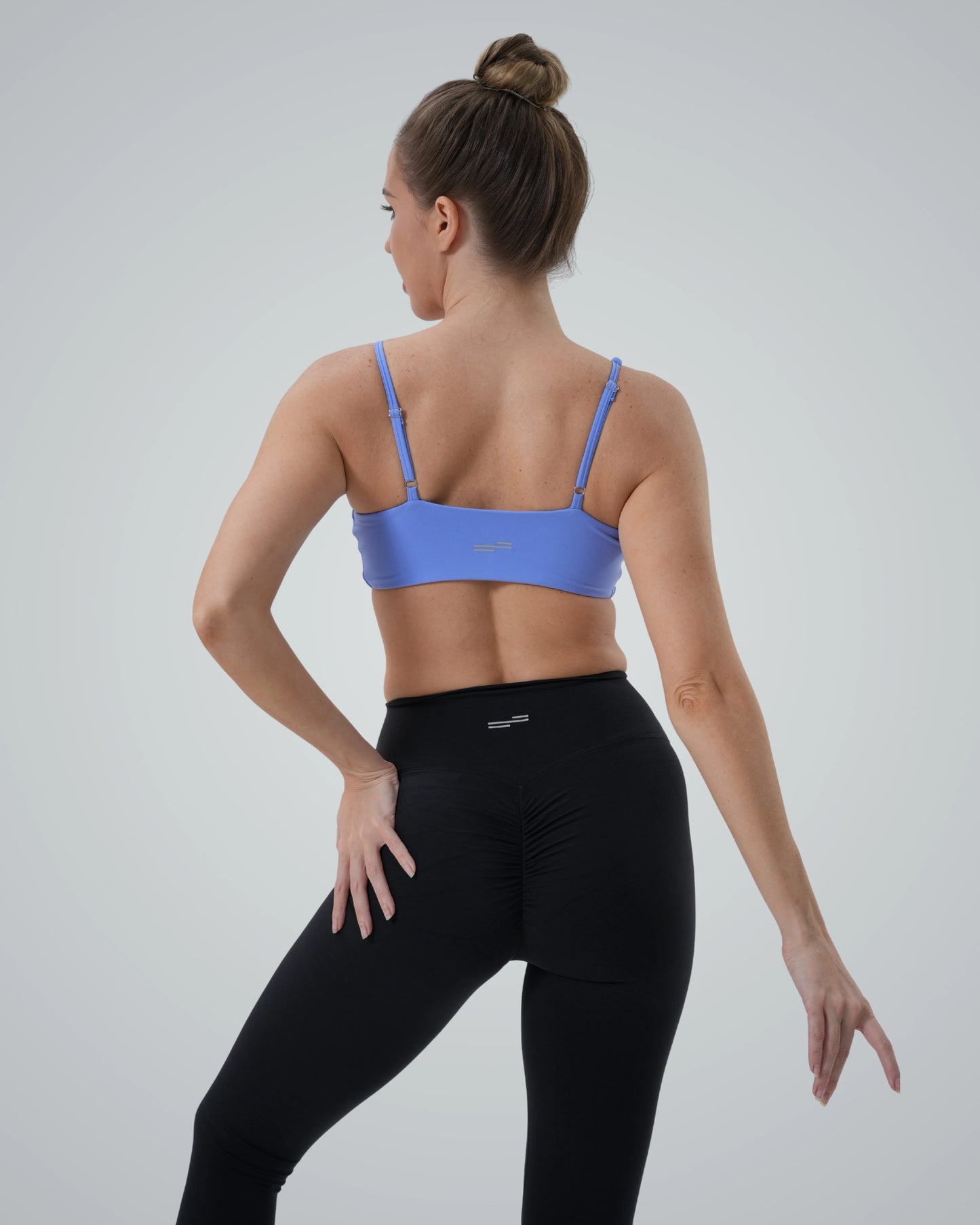 Back view of woman wearing Bandsam's Ignite Ensemble Set, featuring a seamless sports bra and high-waisted leggings, perfect two-piece activewear.