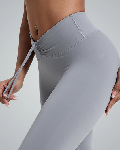 Woman wearing gray activewear leggings with high-rise design and scrunch-back detail, highlighting flexibility and comfort for workouts and lounging.