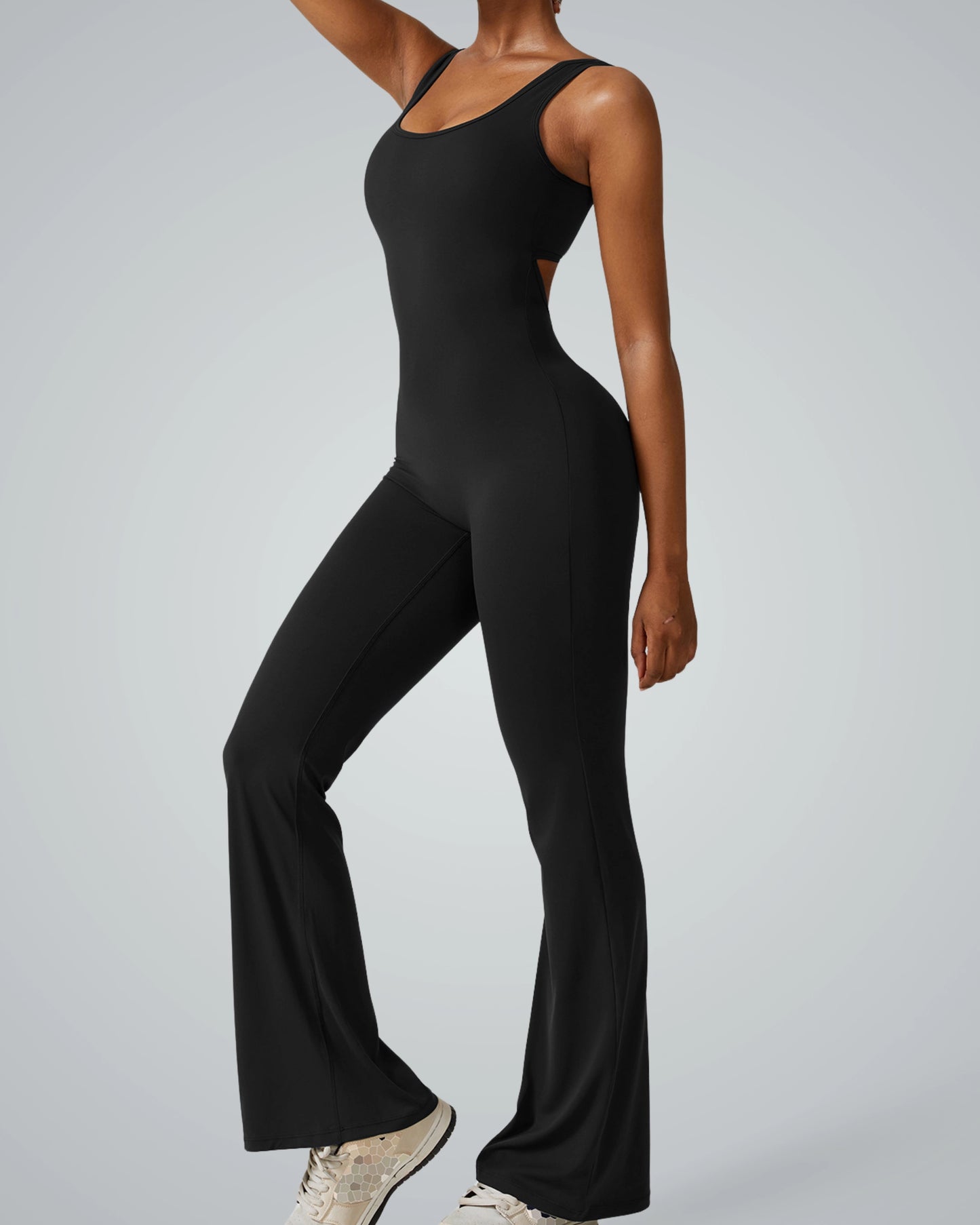 Woman wearing a black Bandsam AuraFlow Jumpsuit, showcasing stretch and comfort with flared legs for yoga, lounging, and outings.