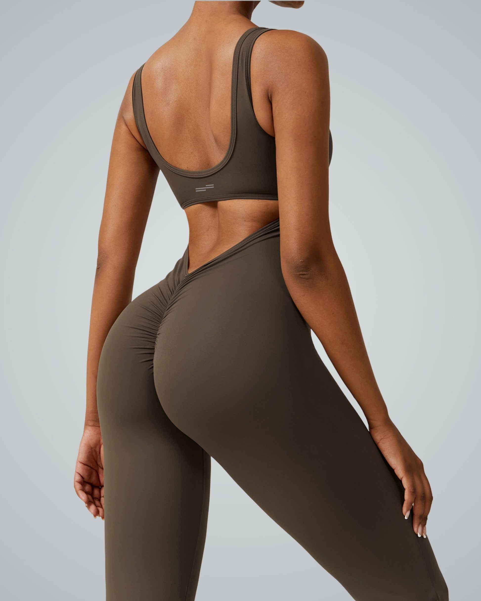 Back view of a woman wearing the Bandsam AuraFlow Jumpsuit, showcasing its stretch, support, and comfort for yoga, pilates, and lounging.