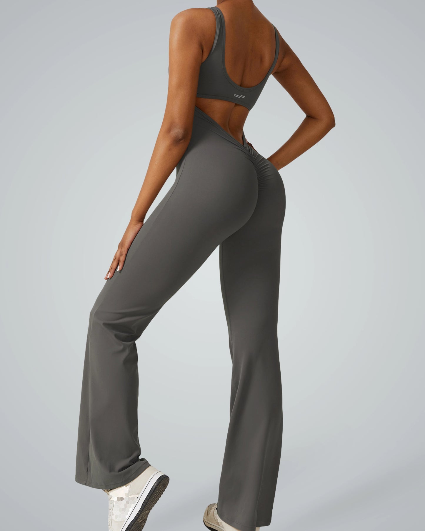 Woman wearing AuraFlow Jumpsuit by Bandsam, showcasing stretch, flexibility, and comfort for yoga, pilates, and lounging.