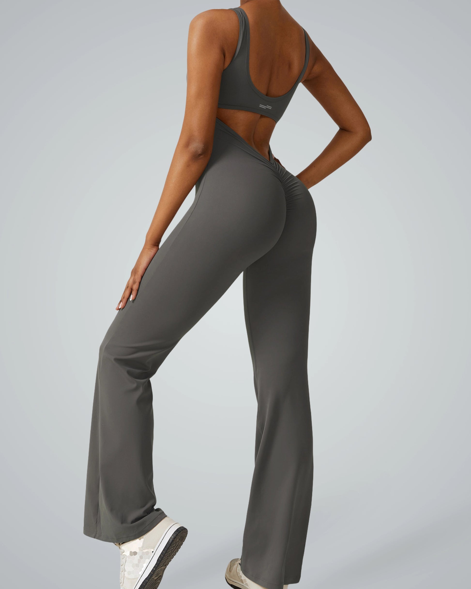 Woman wearing AuraFlow Jumpsuit by Bandsam, showcasing stretch, flexibility, and comfort for yoga, pilates, and lounging.