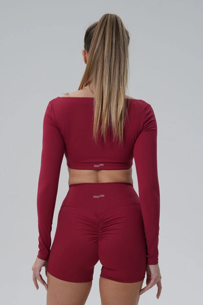 Back view of a woman in a maroon BalanceLine Top by Bandsam, showcasing its elegant and comfortable fit.