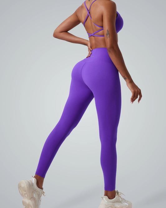 Woman wearing Bandsam ContourCore Set in vibrant purple, showcasing a seamless yoga set with high-waisted leggings and sports bra.