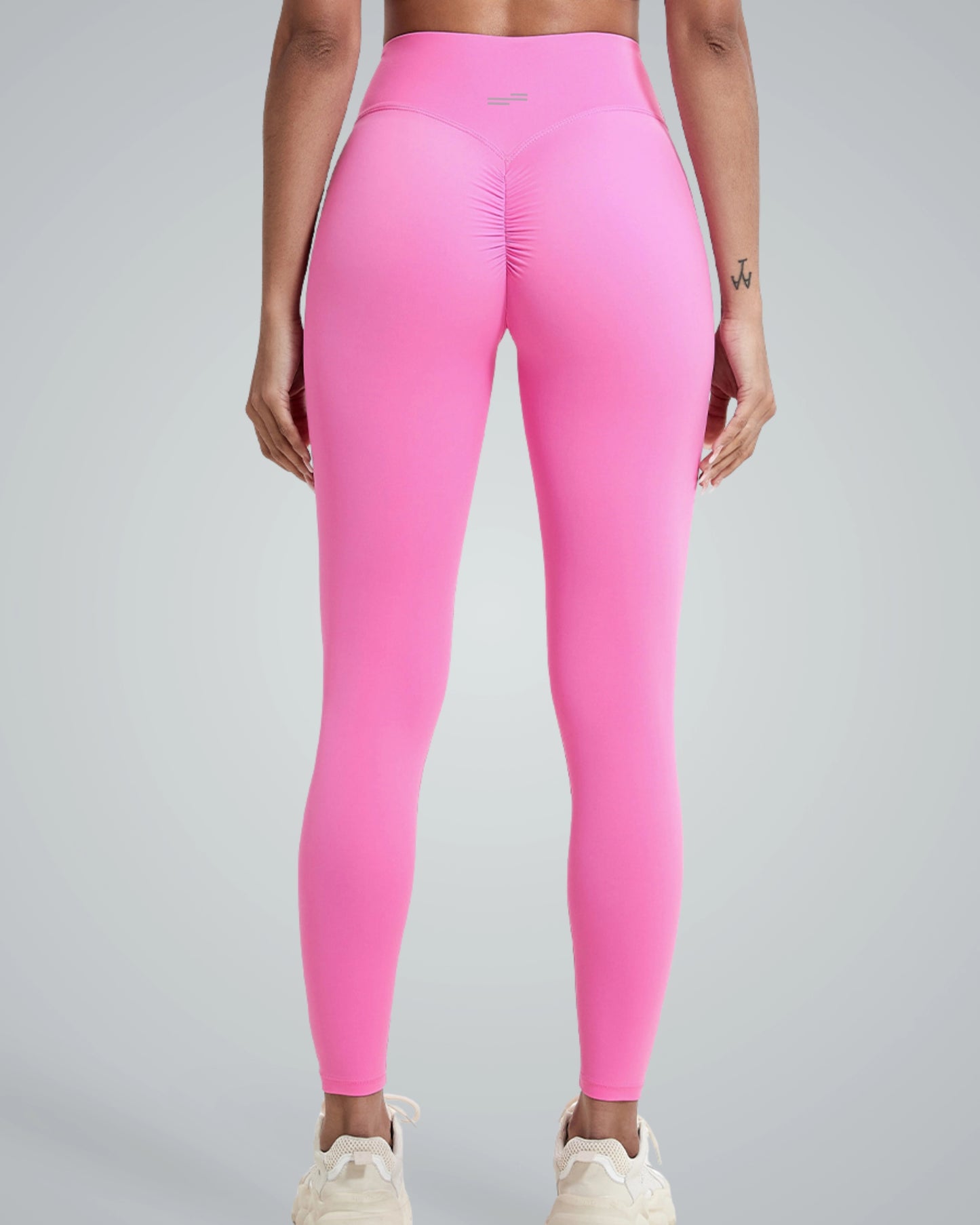 Woman wearing high-rise pink Bandsam 'Coral Crush' leggings with scrunch-back, ideal for yoga, pilates, workout, and lounging in comfort.