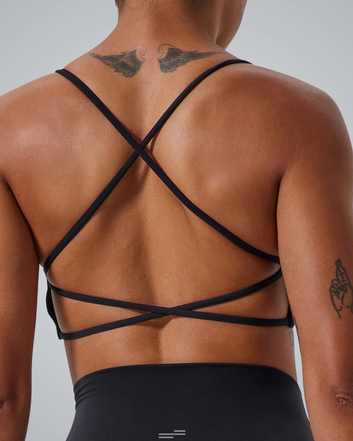 Back view of a woman wearing Bandsam Cross Flow Bra, showcasing breathable fabric and crisscross straps. Stretch, activewear, yoga-ready.