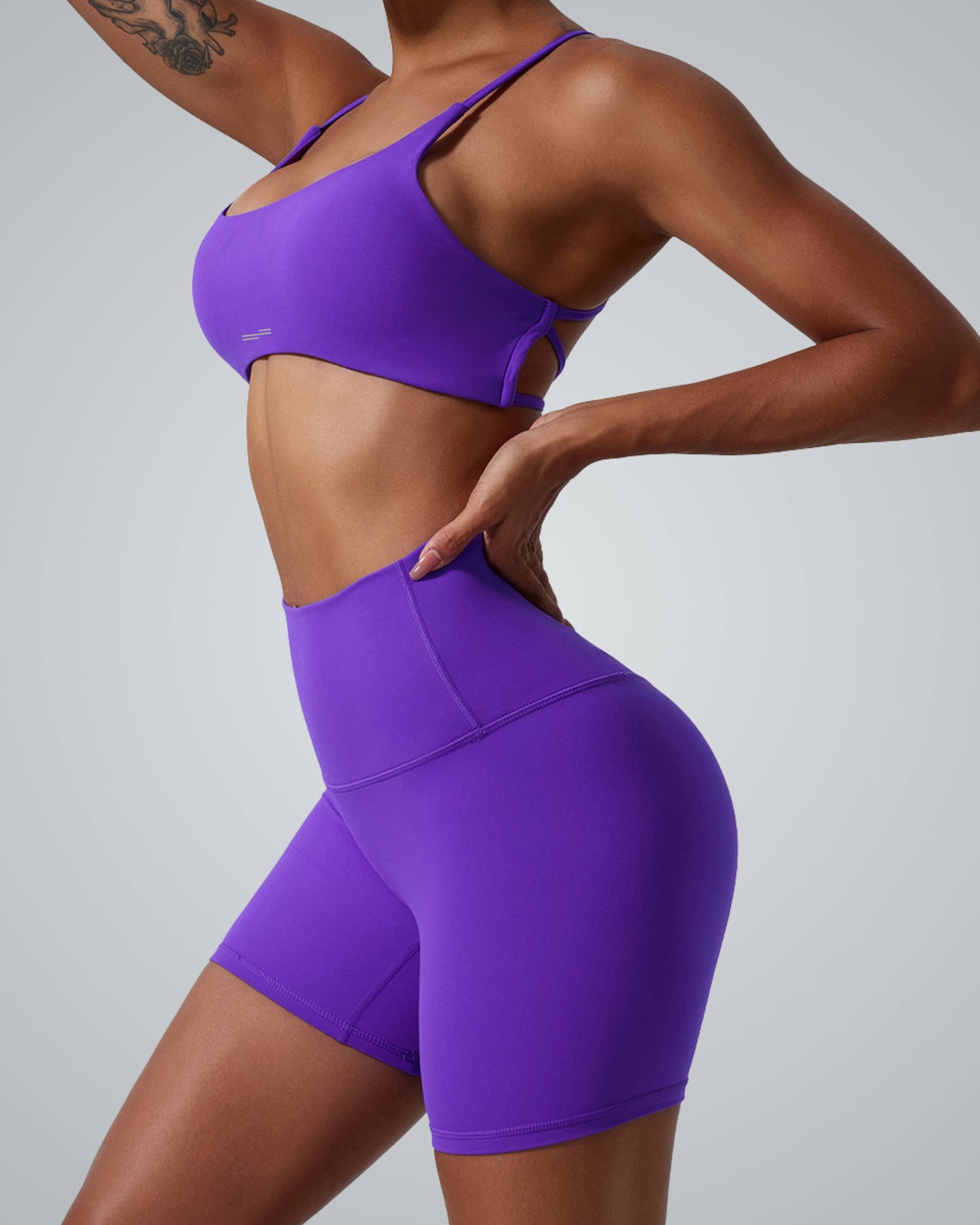 Woman in purple workout set showcasing Bandsam's Cross Flow Bra, ideal for yoga and activewear. Soft, stretchy, and moisture-wicking.