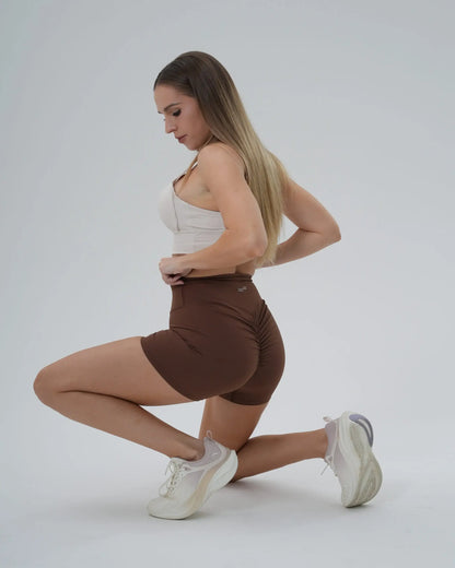 Woman in Bandsam Edge Pro Set performing a stretch, showcasing the seamless gym set; a cute, minimalist workout co-ord for summer fitness.