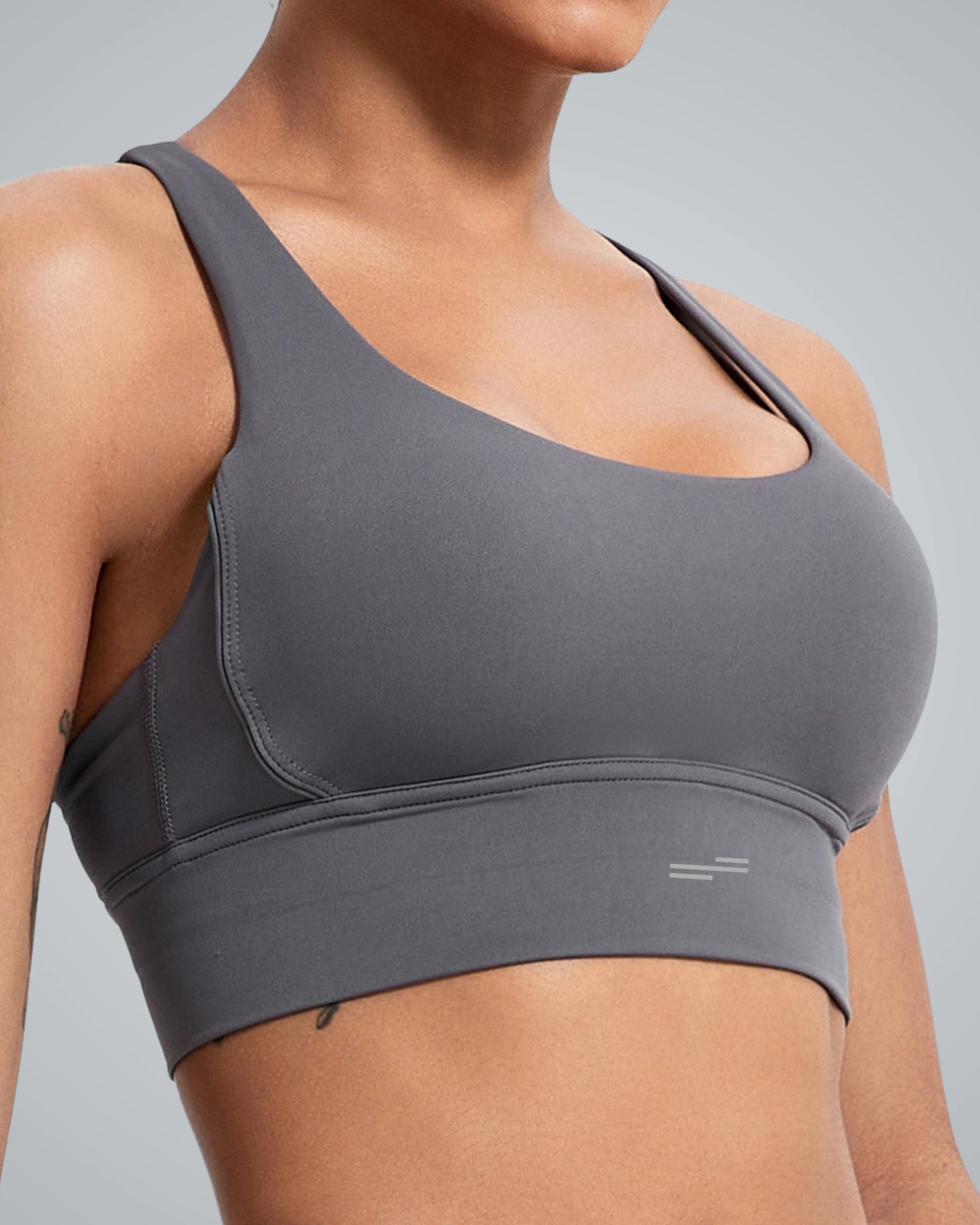 A close-up view of a woman wearing a Bandsam gray sports bra with a modern design, showcasing a comfortable fit and seamless construction, suitable for athletic activities.