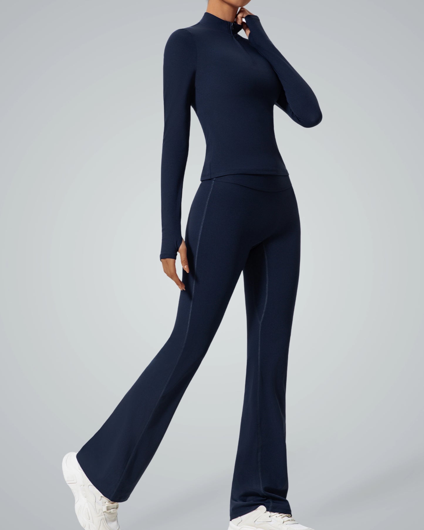 Model wearing Bandsam FluidForce two-piece activewear set with high-neck zip-up and flared leggings for seamless performance and style.