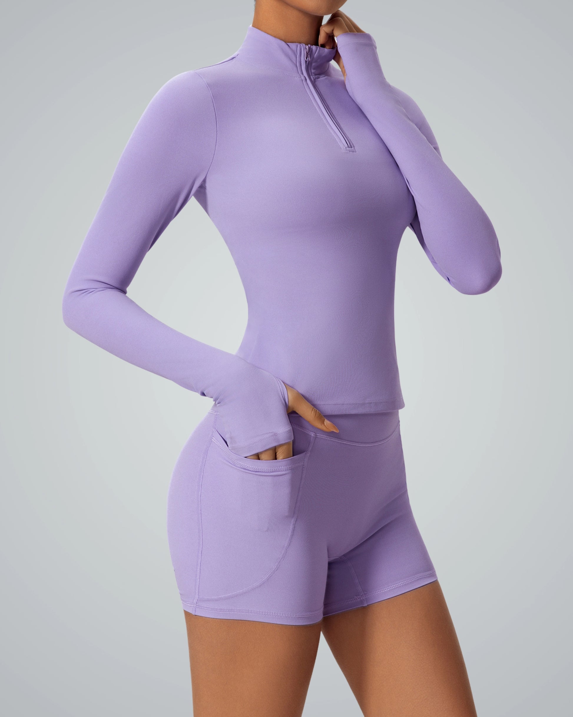Purple matching workout set with high-neck zip-up top and shorts, part of the Bandsam FluidForce activewear collection.