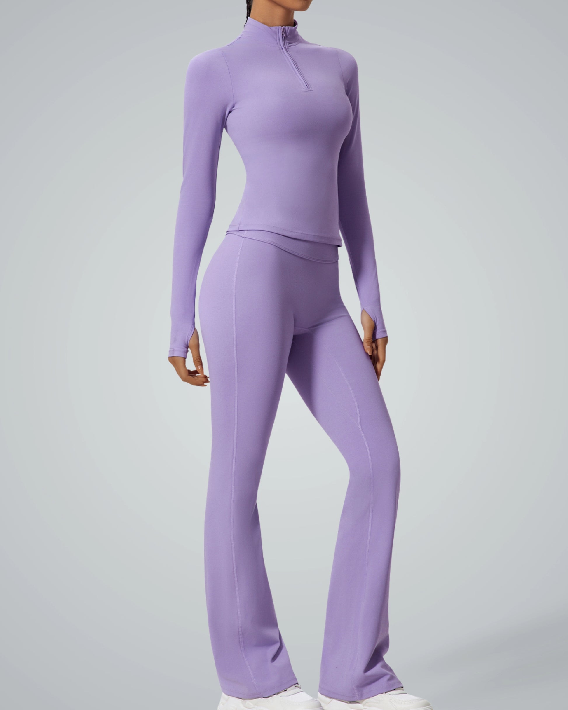 Woman wearing a purple high-neck zip-up long sleeve and pants from Bandsam's FluidForce Set, a seamless yoga set for women.