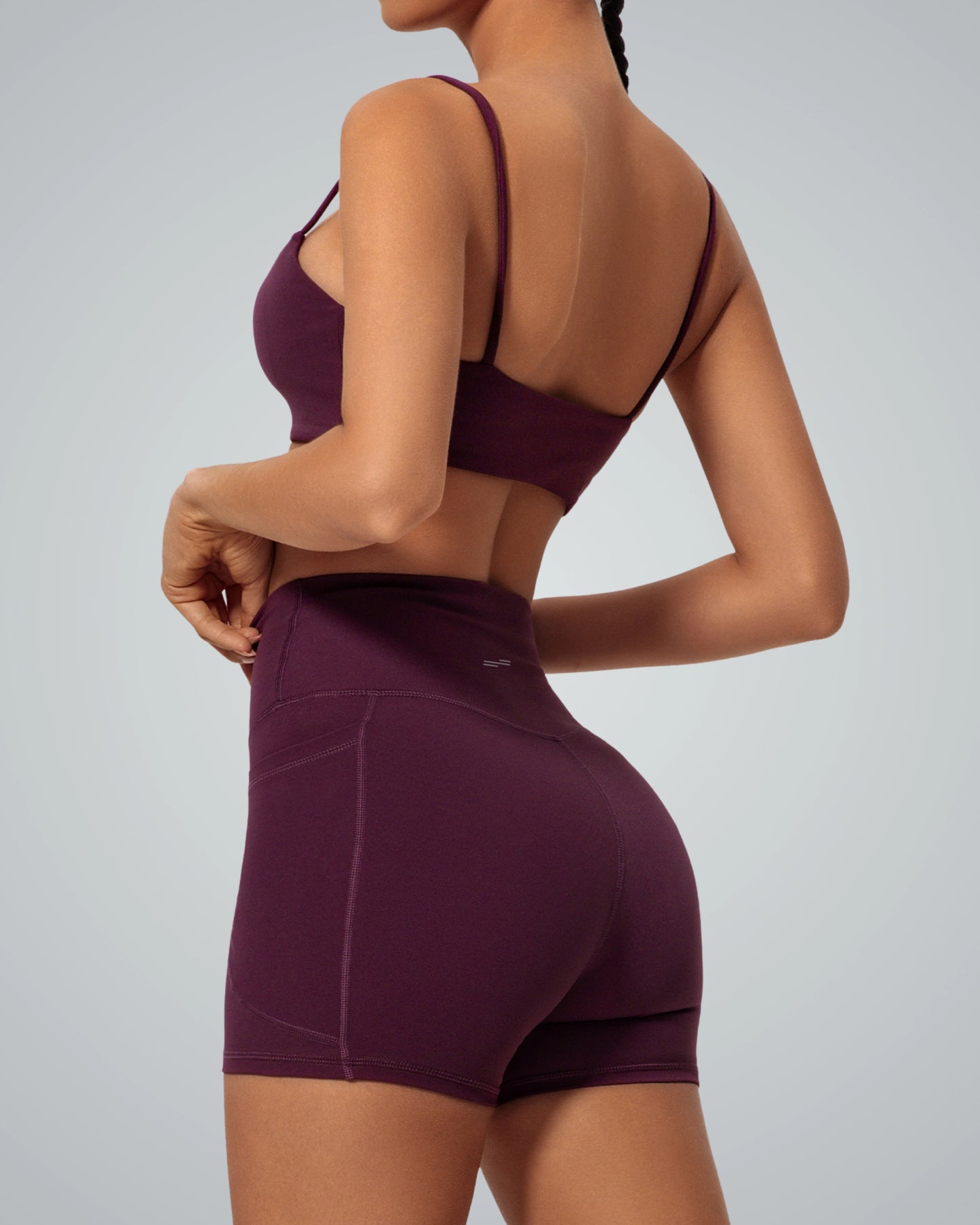 Woman wearing Bandsam FluidForce seamless gym set in bold colorblock, featuring a supportive sports bra and high-waisted shorts.