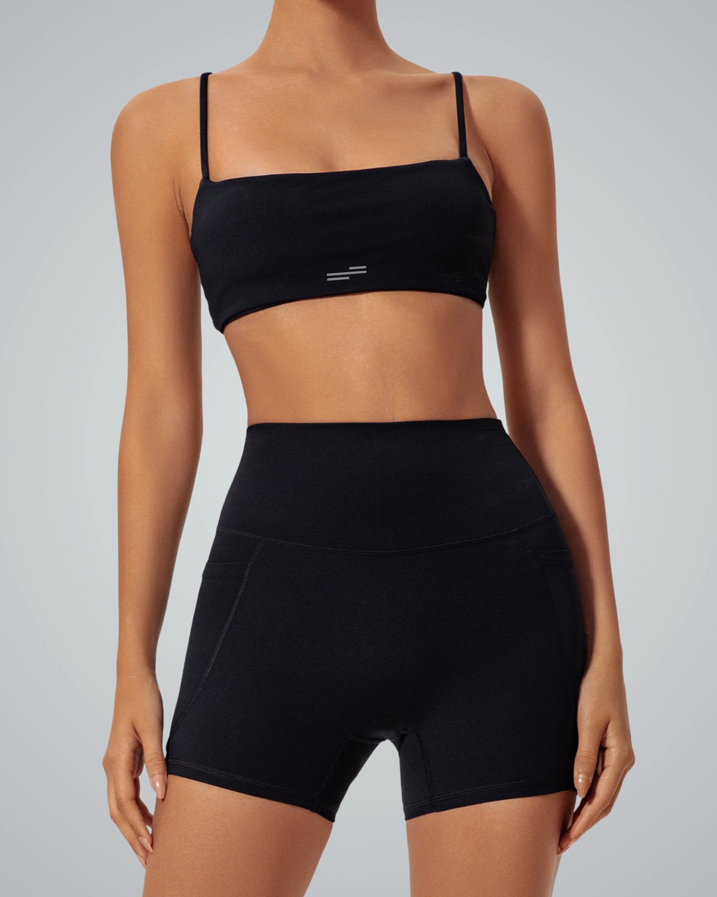 Woman wearing Bandsam GlowLift Bra in black, showcasing stretch, comfort, and support for yoga, pilates, or activewear lounging.