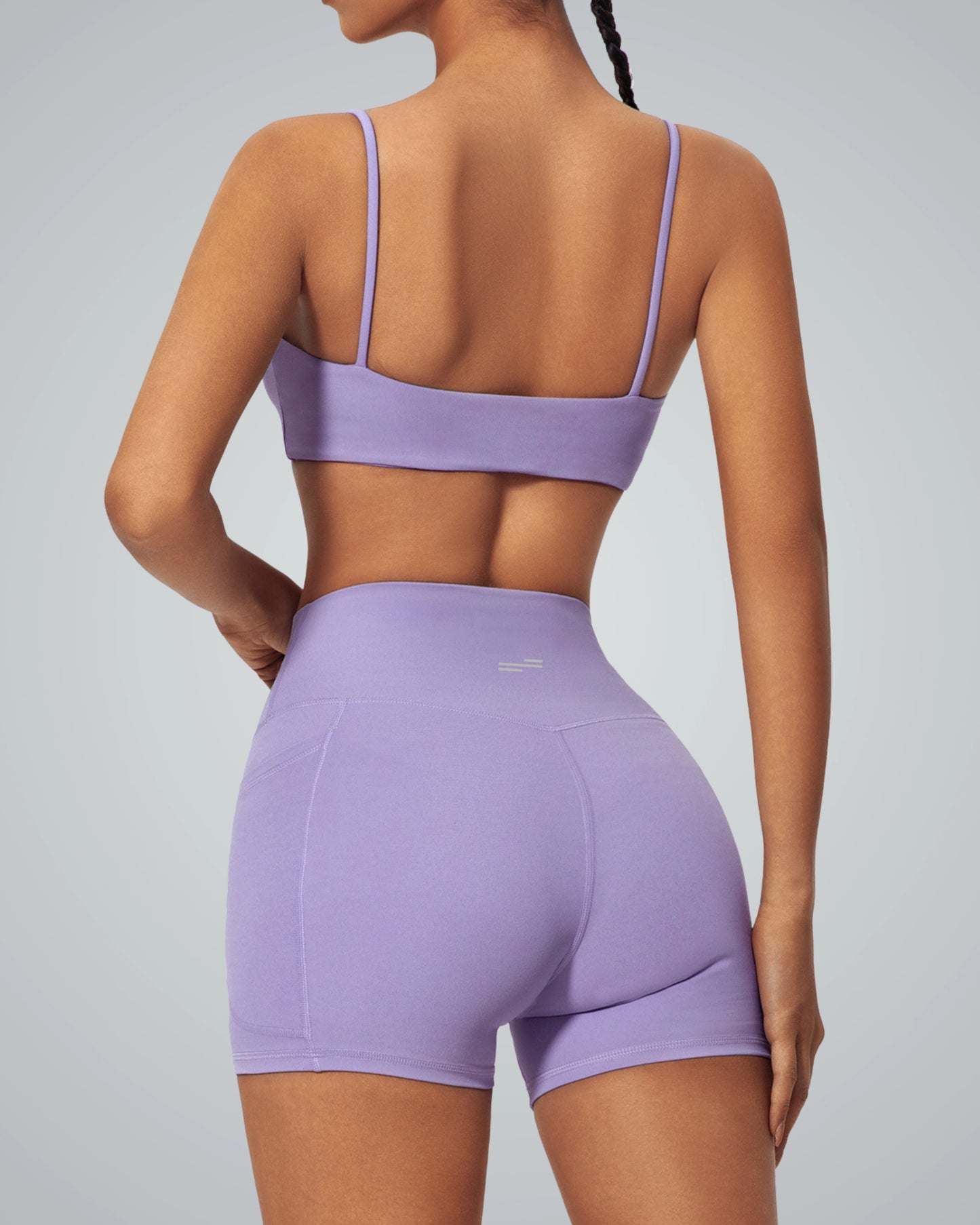 Back view of a woman wearing purple Bandsam GlowLift Bra and shorts, highlighting support, comfort, and flexibility for activewear and lounging.
