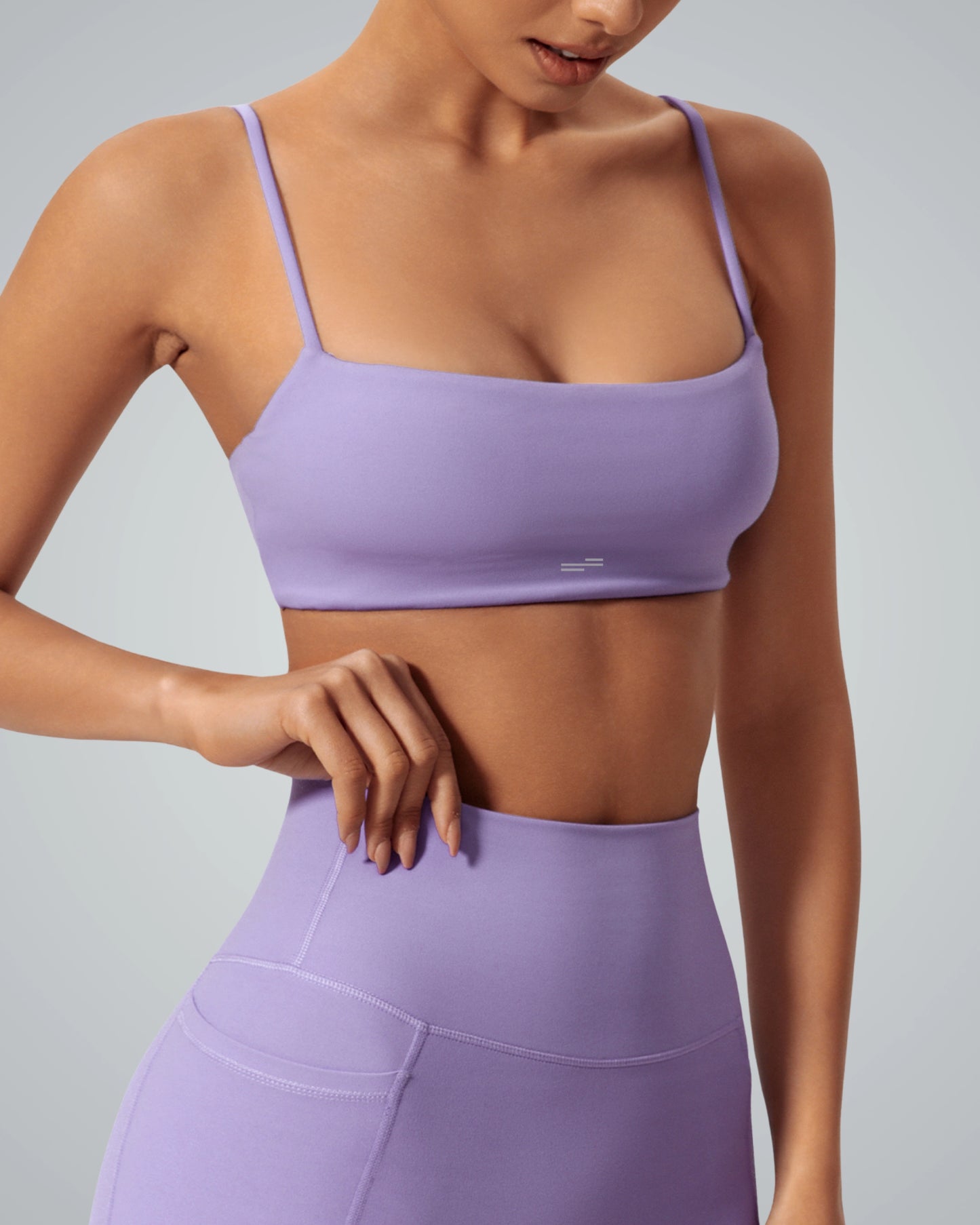 Woman wearing a purple Bandsam GlowLift Bra showcasing support, comfort, and flexibility ideal for yoga, pilates, and lounging.