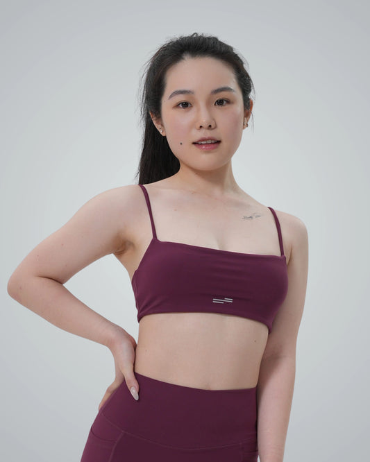 Woman wearing Bandsam GlowLift Bra, seamless maroon activewear offering comfort, support, and flexibility for yoga, pilates, and lounging.