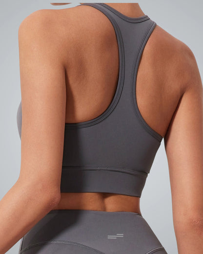 A women wearing a Bandsam fitted gray high impact sports bra and matching leggings is shown from the back against a light gray background. The racerback design offers essential support for any active routine.