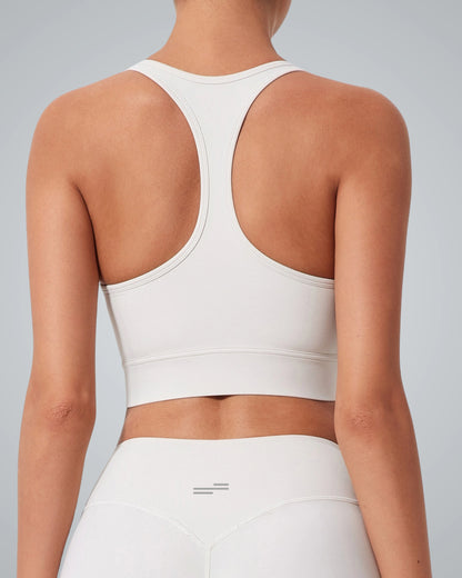 A women wearing the Bandsam GlowMotion Bra, a light-colored high impact sports bra with matching high-waisted leggings, shown from the back against a plain gray background, highlighting both style and support.