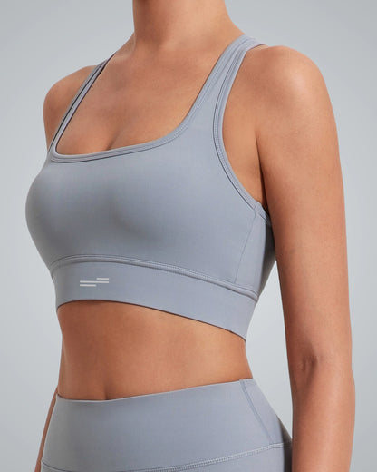 A woman wearing a Bandsam light gray high impact sports bra and matching high-waisted leggings, shown from the neck down against a plain gray background.