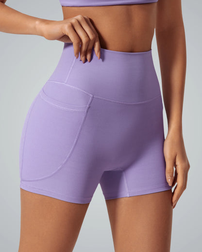 Woman wearing Bandsam LilaFit short in lavender, featuring high-rise fit, pocket, and stretchy activewear fabric for yoga and workouts.