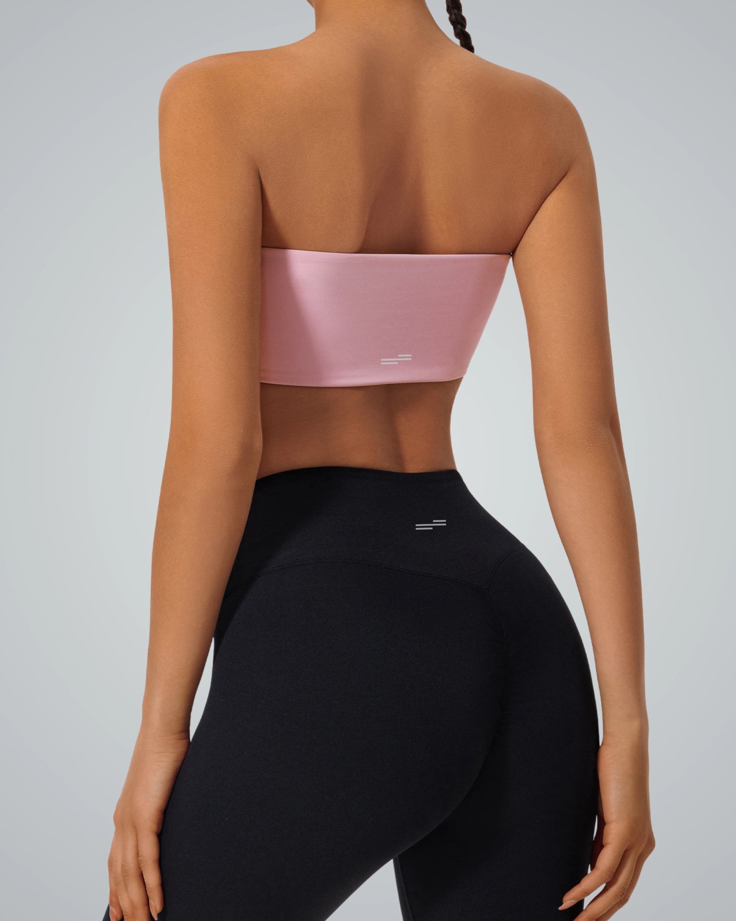 Rear view of woman wearing pink strapless Bandsam LushBreeze Bra and black leggings, ideal for comfort, support, yoga, and activewear.