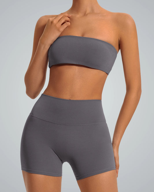 Model wearing LuxeEase Bandeau Set, a seamless two-piece activewear in dark gray, featuring bandeau top and high-waisted shorts.