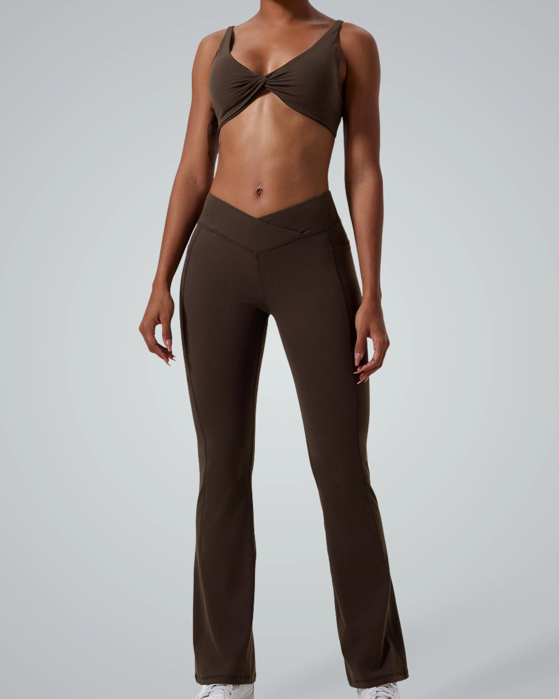 Model wearing Bandsam SculptEase twist-front sports bra and high-waisted flared trousers, two-piece activewear, seamless gym set.