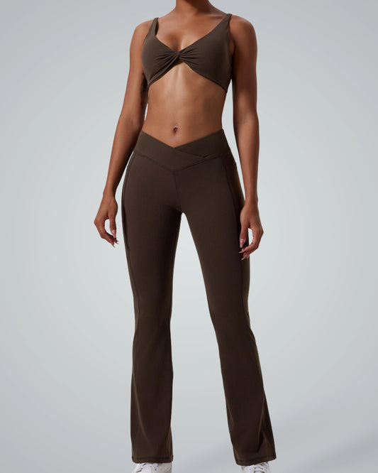 Model wearing Bandsam SculptEase twist-front sports bra and high-waisted flared trousers, two-piece activewear, seamless gym set.