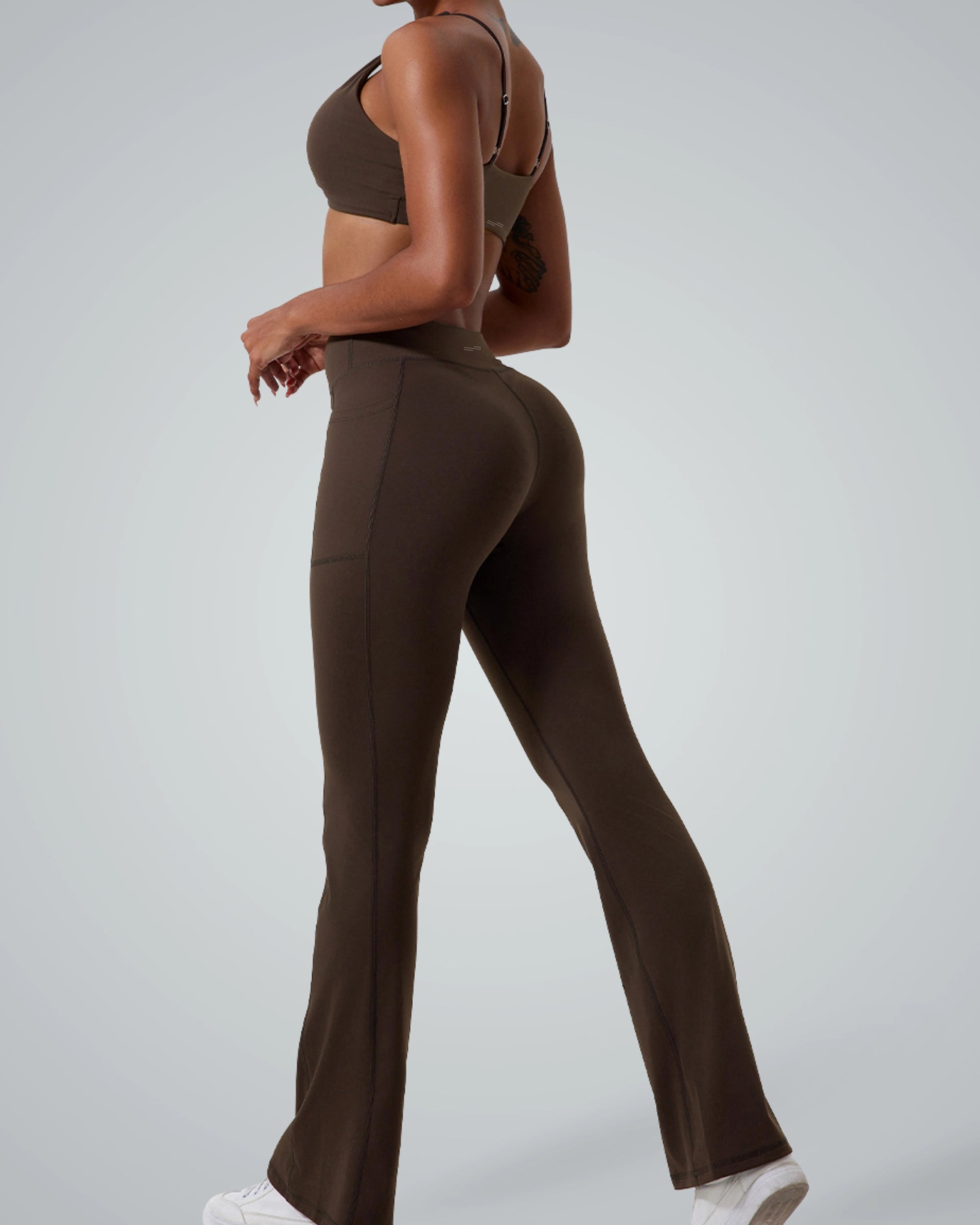Model wearing Bandsam SculptEase Set, a seamless gym outfit with a twist-front sports bra and high-waisted V-shaped flare leggings in brown.