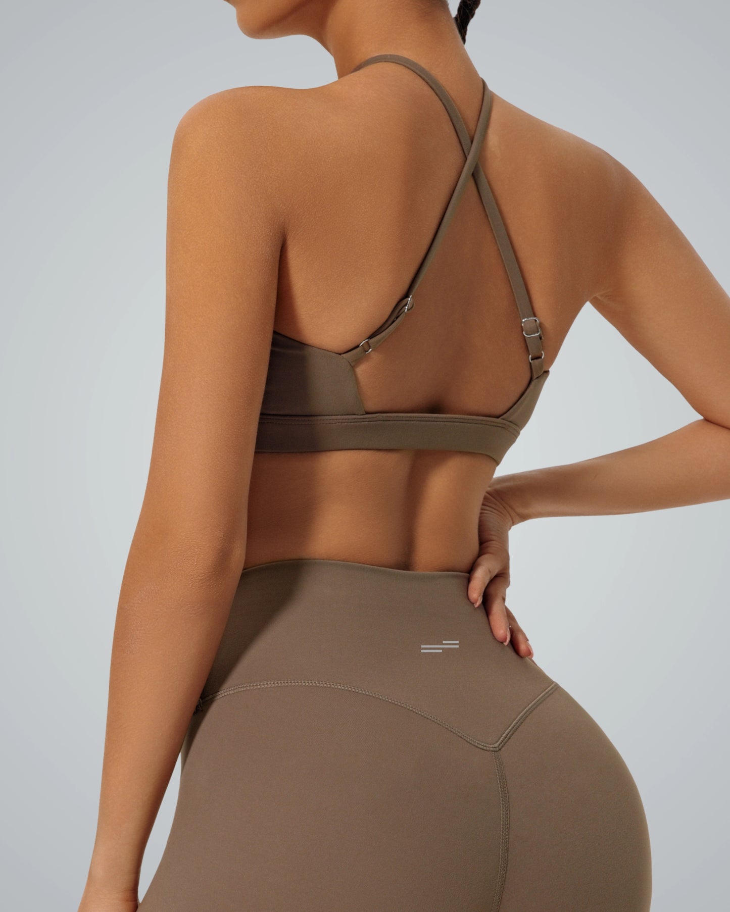 Back view of a woman wearing a Bandsam ShapeSync Bra with a crisscross design, ideal for comfort, flexibility, and support during yoga or workouts.