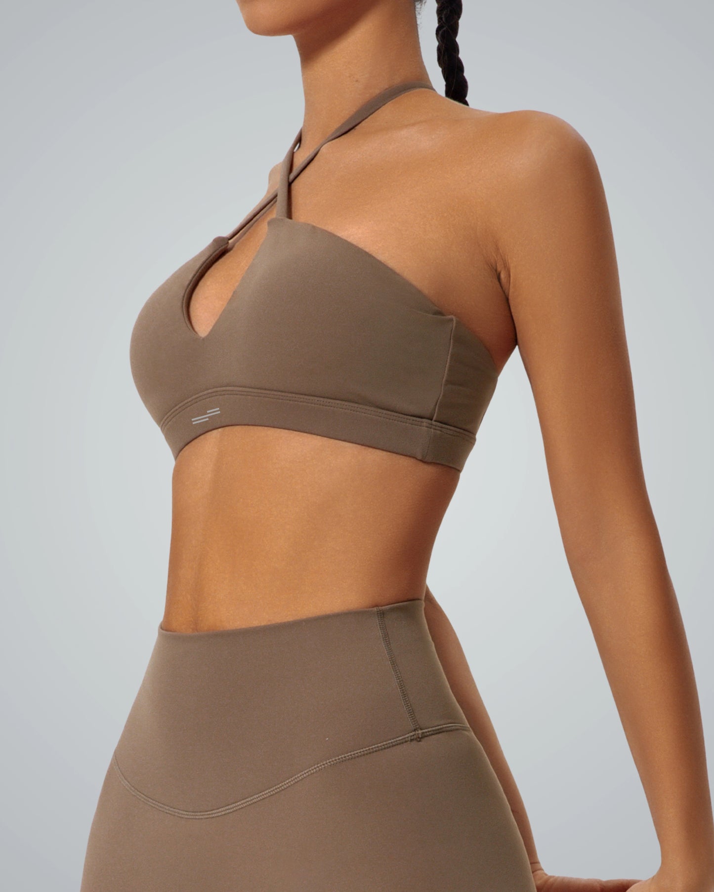Woman wearing Bandsam ShapeSync Bra in brown showcasing modern crisscross design, perfect for yoga, pilates, workout, and lounging.