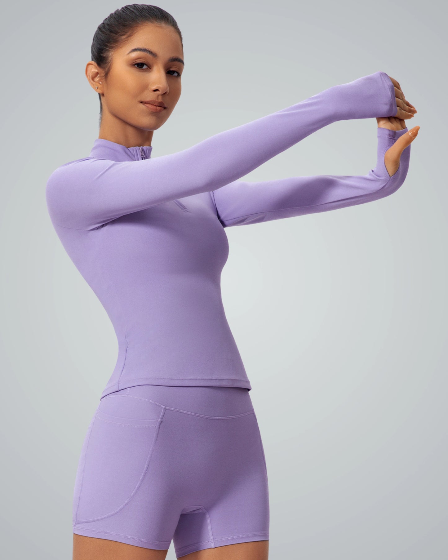Woman wearing Bandsam SmoothFit Long Sleeve in lilac, ideal for yoga and workouts, offers style, stretch, and comfort.