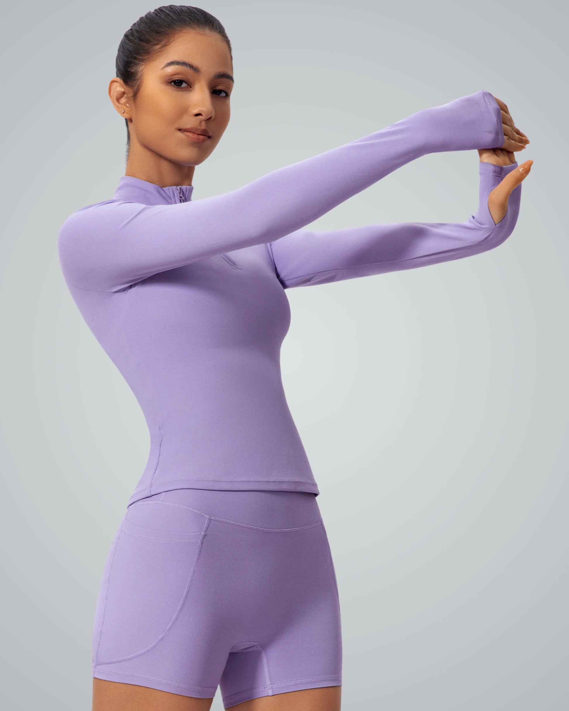 Woman wearing Bandsam SmoothFit Long Sleeve in lilac, ideal for yoga and workouts, offers style, stretch, and comfort.