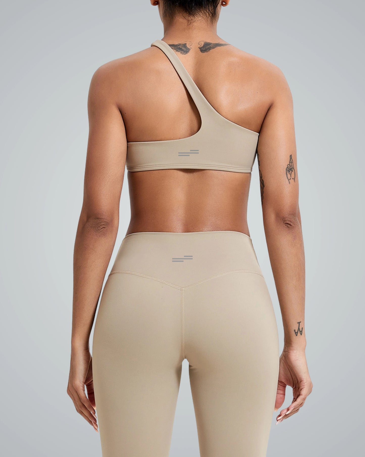 Back view of a model wearing Bandsam ToneTwin Set, a seamless two-piece activewear with high-waisted leggings and an asymmetrical top.