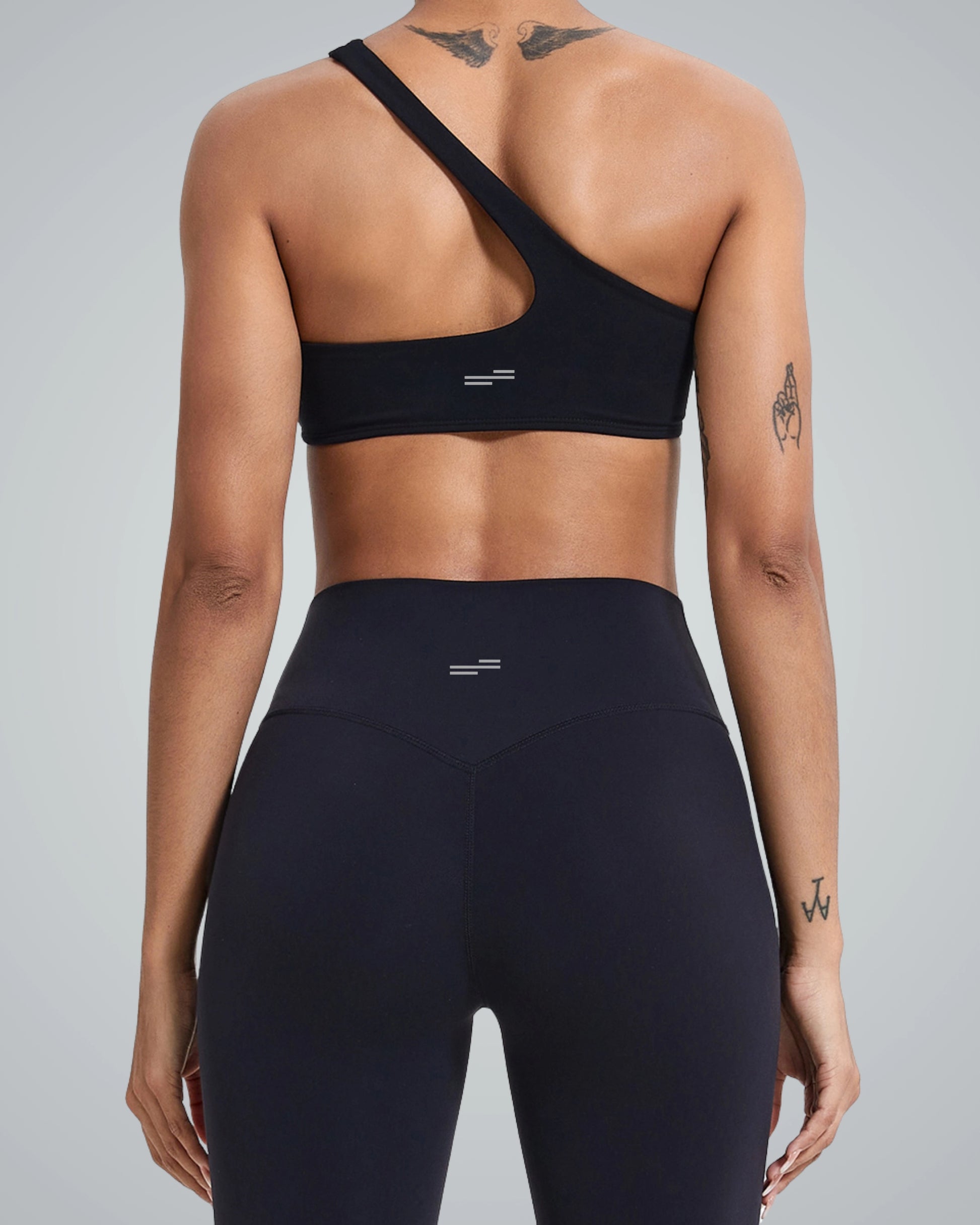 Back view of Bandsam ToneTwin Set, featuring a black asymmetrical sports bra and high-waisted leggings - a seamless gym set.