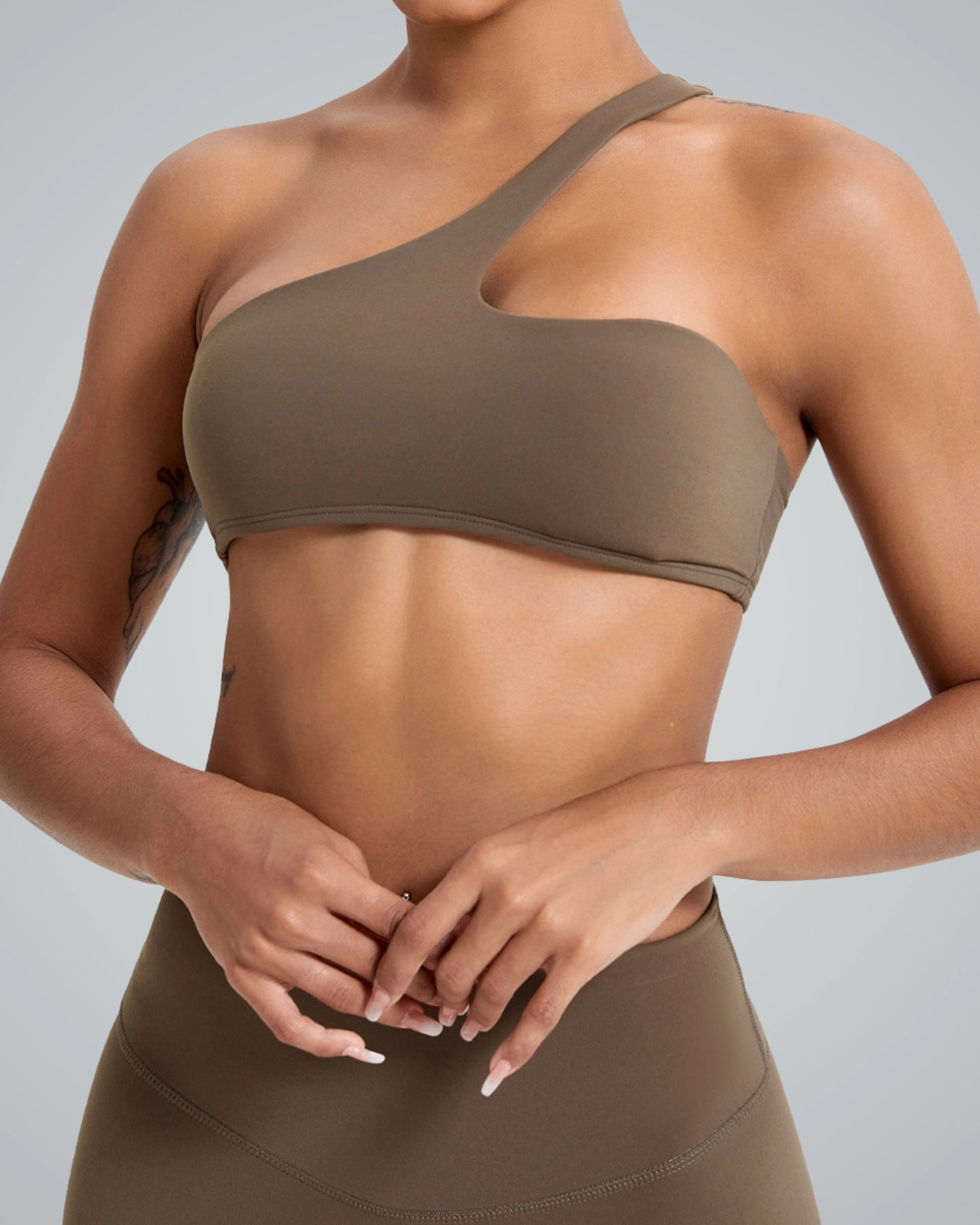ToneTwin Set by Bandsam featuring an asymmetrical top and high-waisted leggings. Stylish athleisure outfit for exercise or casual wear.