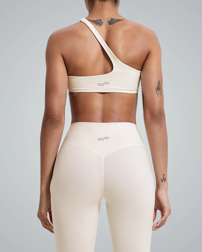 Back view of Bandsam's ToneTwin Set featuring an asymmetrical top and high-waisted leggings, a matching workout set in minimalist style.