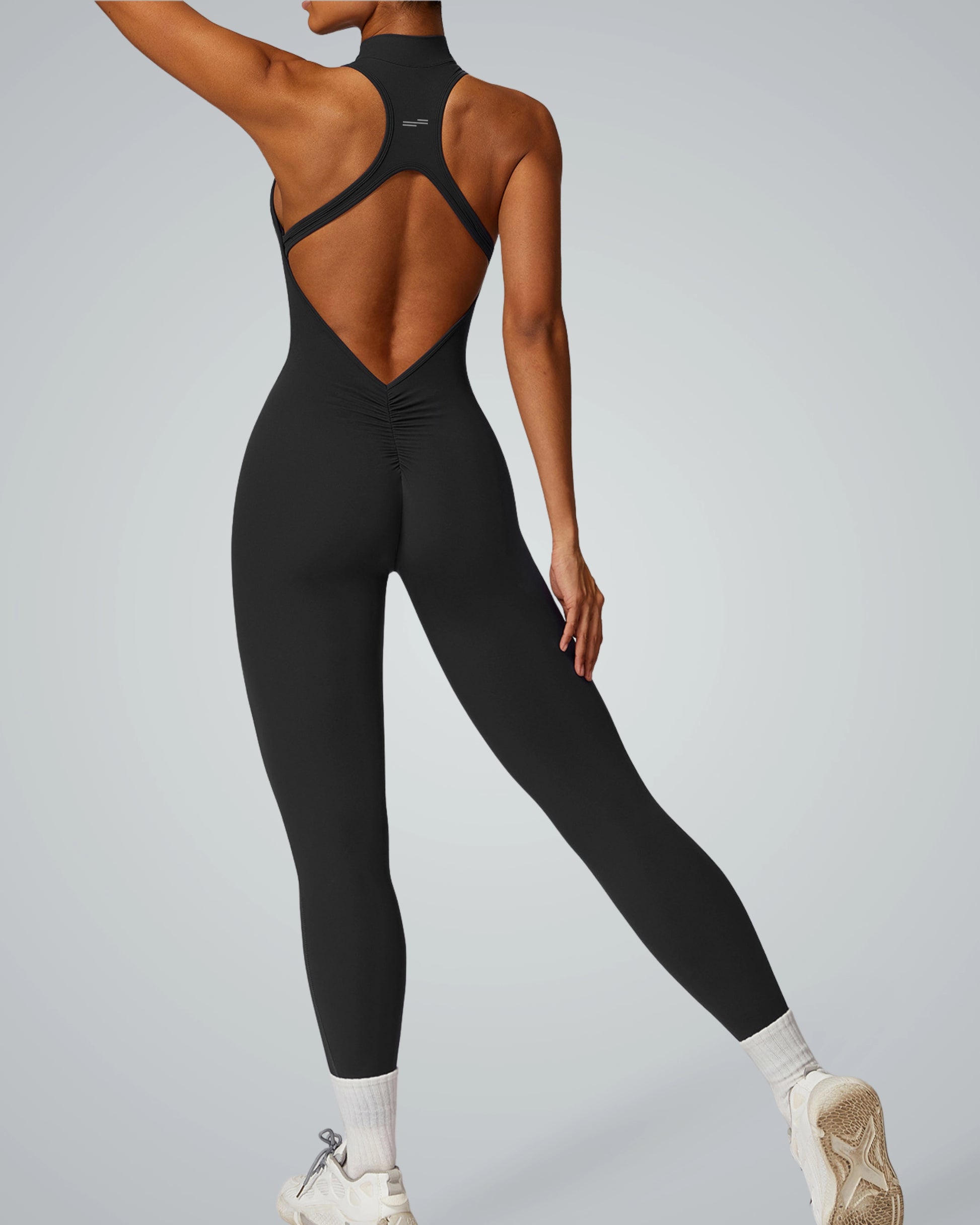 Back view of a woman in a black VelocityVibe Jumpsuit by Bandsam, designed for stretch, comfort, and activewear, suitable for yoga or workouts.