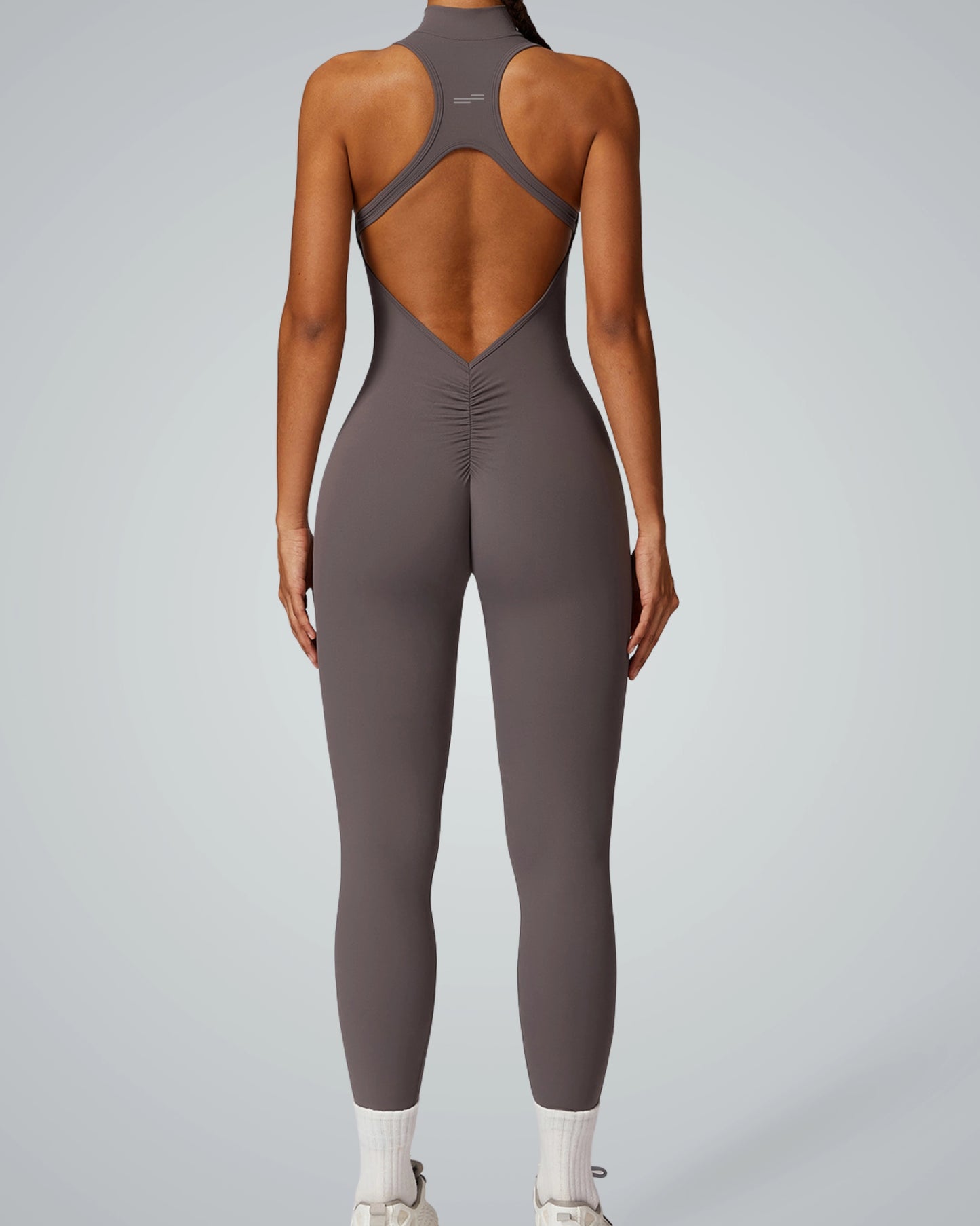 Woman in a charcoal Bandsam VelocityVibe jumpsuit showcasing flexible activewear ideal for yoga, pilates, and lounging.