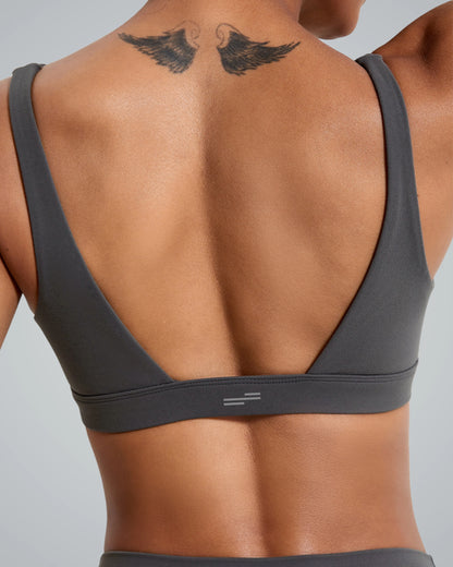 Back view of woman wearing grey Verda Vibe Bralette by Bandsam, showcasing stretch support for yoga and lounging in soft, flexible material.