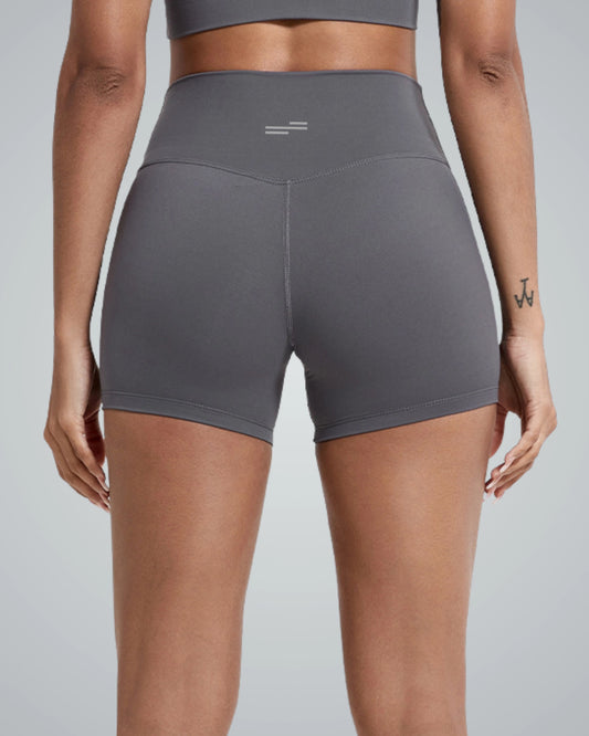 Back view of woman wearing gray Bandsam VibrantMove Shorts, highlighting stretch, comfort, and support for yoga and activewear.