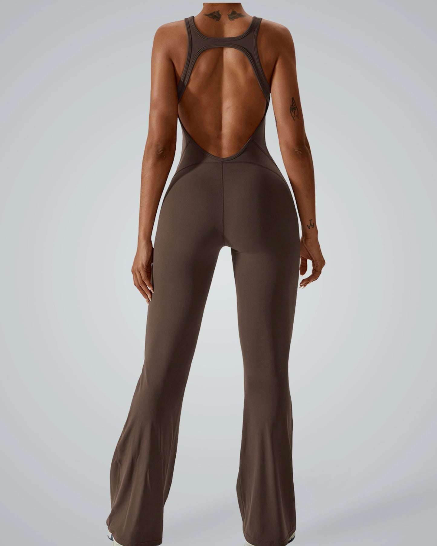 Back view of a woman wearing Bandsam VitalFlare Jumpsuit, a stretch activewear piece with flared legs, ideal for yoga and lounging.