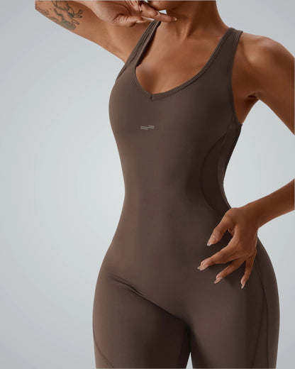 Woman wearing Bandsam VitalFlare Jumpsuit for yoga, showcasing stretch, support, and comfort in brown activewear.
