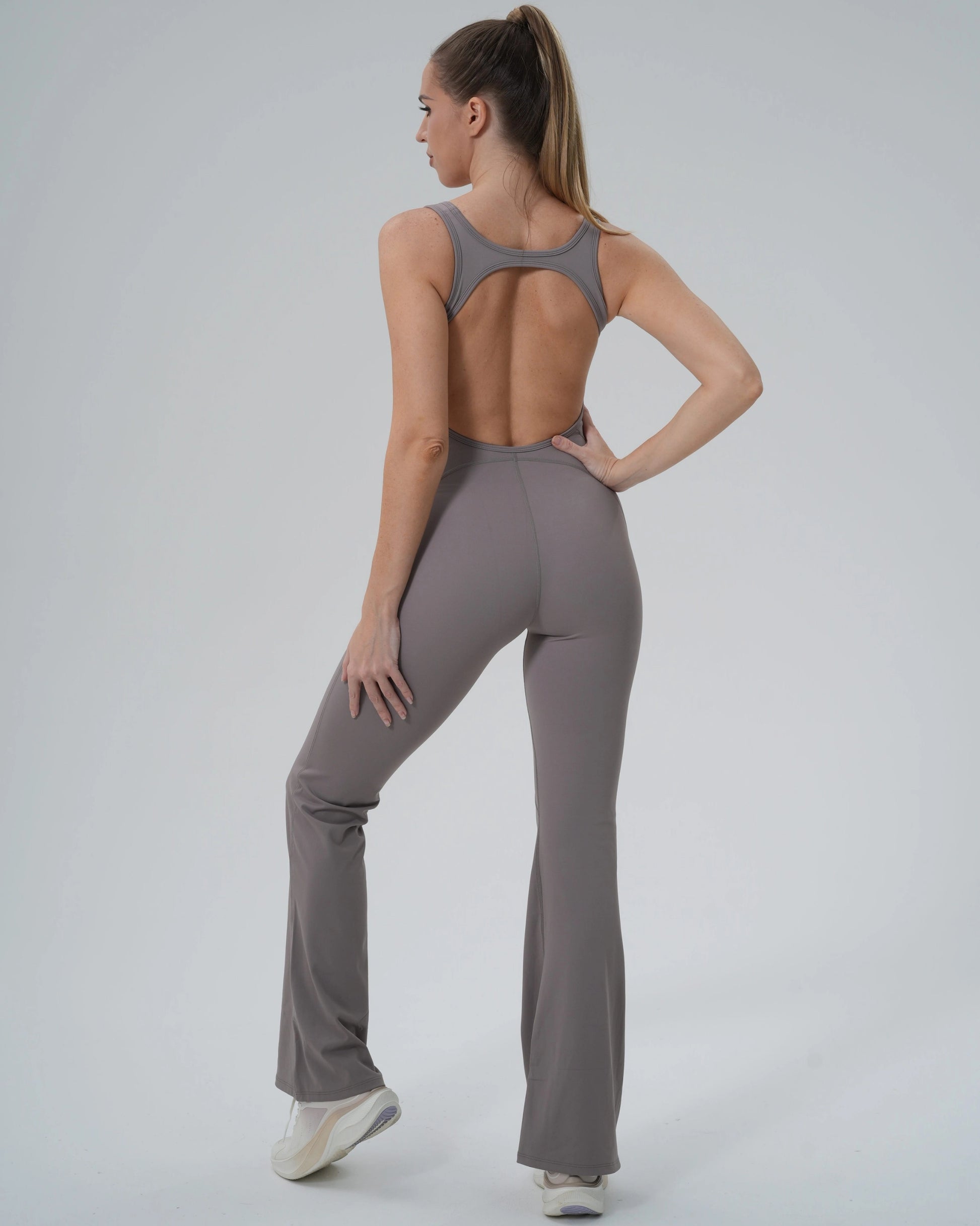 Woman in Bandsam VitalFlare Jumpsuit, showcasing flared leg activewear ideal for yoga, pilates, or lounging. Stretchy, soft, and supportive.
